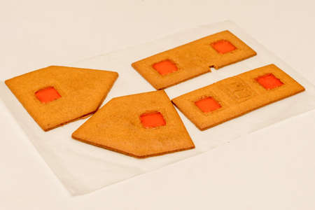 Building of gingerbread house. Parts on the baking paper with windows made from melted candies.の写真素材