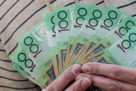 Hands holding australian dollars 100 banknotes. Finance and payment concept.の写真素材
