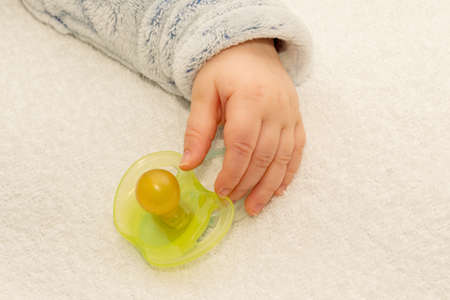 Close up of baby little hand with a pacifier dummyの写真素材
