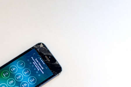 Sydney, Australia 2019-09-13 Smartphone with badly smashed screen is showing apple logo while...