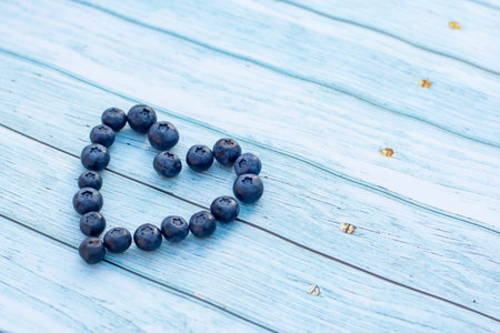 Superfood berries: blueberry heart on a wooden backgroundの写真素材