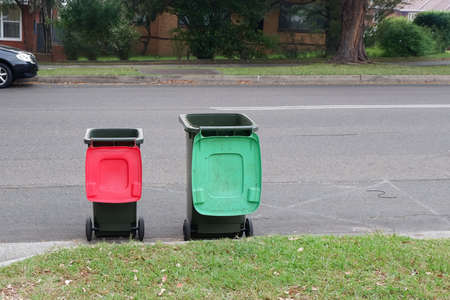 Australian garbage wheelie bins with colourful lids for recycling and general household waste lined up on the street kerbside for council rubbish collectionの写真素材