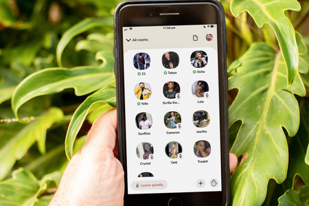 Sydney, Australia - 2021-01-17 Clubhouse drop-in audio chat on the phone screen. Hand holding a phome with clubhouse app.のeditorial素材
