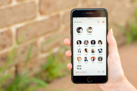Sydney, Australia - 2021-02-19 Clubhouse drop-in audio chat on the phone screen. Hand holding a phome with clubhouse app.のeditorial素材