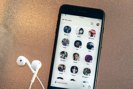 Sydney, Australia - 2021-02-19 Clubhouse drop-in audio chat on the phone screen. Headphones.のeditorial素材