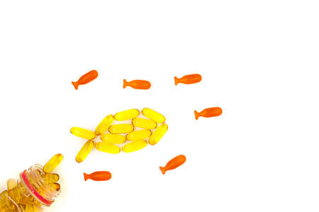 Omega-3 fish oil capsules on white background in a shape of a fish. Vitamins and supplementsの写真素材