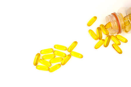 Omega-3 fish oil capsules on white background in a shape of a fish. Vitamins and supplementsの写真素材