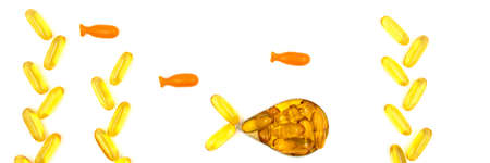 Omega-3 fish oil capsules in a shape of a fish on white background. Vitamins and supplements