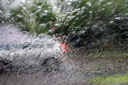 Blurred defocused image of heavy torrential rain through the windscreen in Sydney. Rainfall flash...