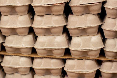 Dozen eggs carton cardboard boxes piled at the market. Packaged eggs background