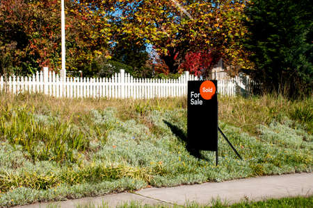 For sale sign near the residential building house with 'SOLD' sold sticker on it. Auction clearance rateの写真素材