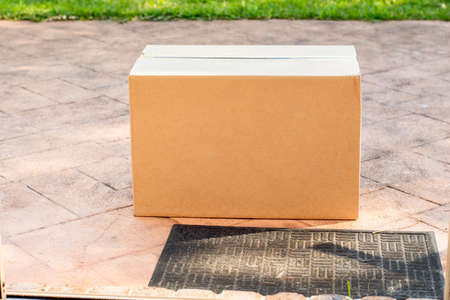 Parcel box delivered to a front door of residential building. Online shopping and delivery. Post shippingの写真素材