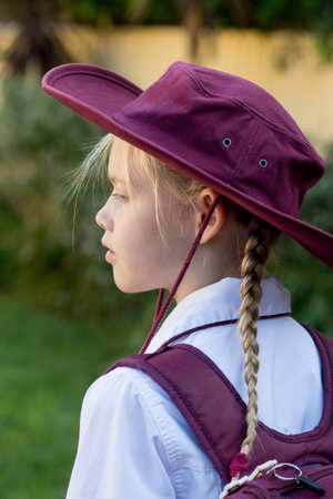 A girl wearing school uniform, white shirt, maroon backpack and maroon hat Back to school. Return to classrooms after COVID-19 outbreak in Australiaの写真素材
