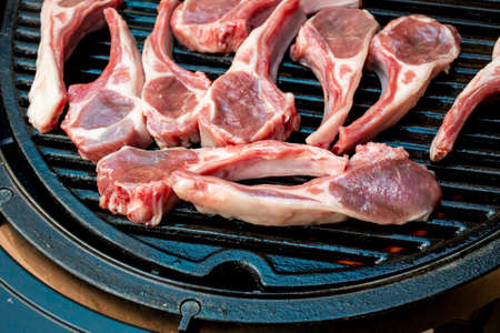 Lamb cutlets chops grilling on barbecue plate . Backyard BBQ grill cooking. Australia Day celebration party mealの写真素材