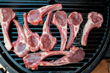 Lamb cutlets chops grilling on barbecue plate . Backyard BBQ grill cooking. Australia Day celebration party mealの写真素材
