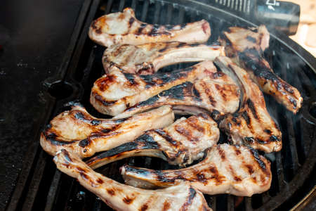 Lamb cutlets chops grilling on barbecue plate . Backyard BBQ grill cooking. Australia Day celebration party mealの写真素材