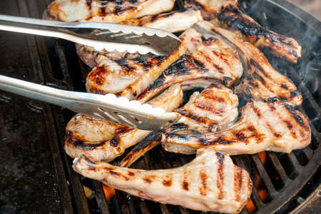 Lamb cutlets chops grilling on barbecue plate . Backyard BBQ grill cooking. Australia Day celebration party mealの写真素材
