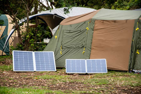 Portable foldable solar panels and Tent at the campsite surrounding by nature. Camping and recreation conceptの写真素材