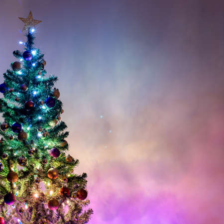 Christmas tree light up with colorful christmas lights on beautiful enchance background with copy space. Magic of Christmasの写真素材