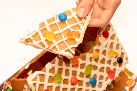 Piece of dissasembled homemade gingerbread house decorated with icing and sweets. Eating of gingerbread house after Christmas celebrationの写真素材