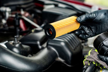 Changing car oil filter. DIY change engine motor oil. At home vehicle maintenance. Oil Filter replacement. New Oil filterの写真素材