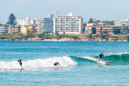 Sydney, Australia 2021-03-13 Surfers learning to catch waves in the ocean at Cronulla, NSW, Australia. Learn to surf on calm ocean.のeditorial素材