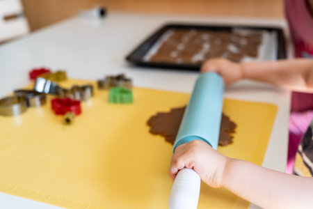 Child helps making gingerbread cookies with various Christmas cookie cutters. Gingerbread dough. Family Christmas fun momentsの写真素材