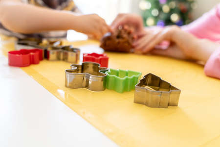 Selective focus. Kids making gingerbread cookies with various Christmas cookie cutters. Gingerbread dough. Family Christmas fun momentsの写真素材