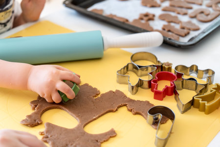 Selective focus. Kids making gingerbread cookies with various Christmas cookie cutters. Gingerbread dough. Family Christmas fun momentsの写真素材