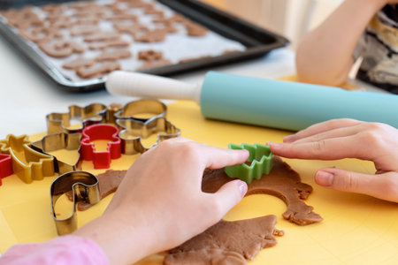 selective focus. Kids making gingerbread cookies with various Christmas cookie cutters. Gingerbread dough. Family Christmas fun momentsの写真素材