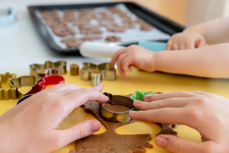 Selective focus. Kids making gingerbread cookies with various Christmas cookie cutters. Gingerbread dough. Family Christmas fun momentsの写真素材