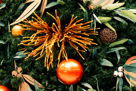 Christmas tree decorated in tropical style with golden and orange ornaments ball. Close up backgroundの写真素材