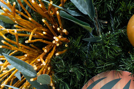 Christmas tree decorated in tropical style with golden and orange ornaments ball. Close up backgroundの写真素材