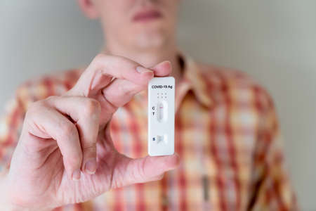 Man holding Covid-19 rapid antigen test cassette with negative result of rapid diagnostic test. Self-testing kit at homeの写真素材