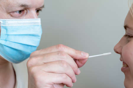 man wearing face mask and teenage girl while doing rapid antigen test nasal swab. Rapid diagnostic...