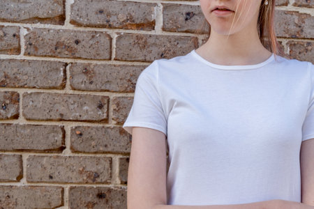 Girl wearing mockup white t-shirt on brick wall background. Template copy space fashionの写真素材