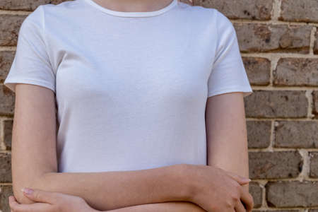 Girl wearing mockup white t-shirt on brick wall background. Template copy space fashionの写真素材