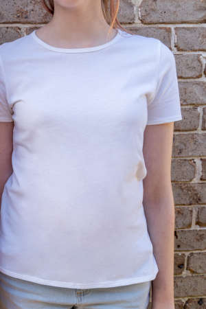 Girl wearing mockup white t-shirt on brick wall background. Template copy space fashionの写真素材