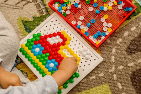 Toddler playing pegboard mosaic. Early child development. Fine motor skills. Learning and creativityの写真素材