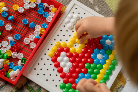 Toddler playing pegboard mosaic. Early child development. Fine motor skills. Learning and creativityの写真素材