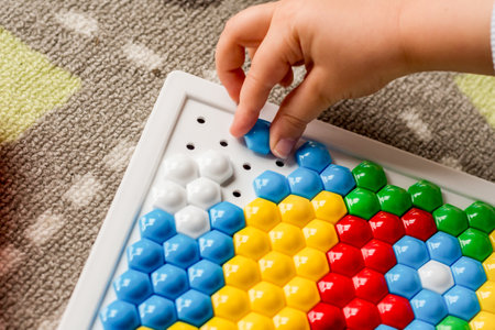 Toddler playing pegboard mosaic. Early child development. Fine motor skills. Learning and creativityの写真素材