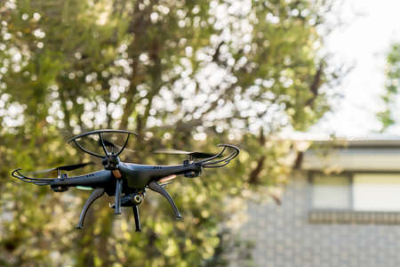 Drone camera quad copter flying near residential buildings. Drone photography and videography. Drone flight.の写真素材