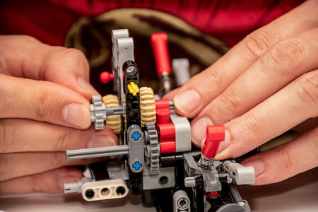 Hands holding piece of a comlpex machinery made from plastic construction kit parts detailsの写真素材