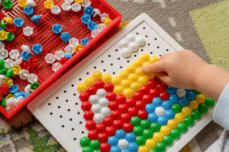 Toddler playing pegboard mosaic. Early child development. Fine motor skills. Learning and creativityの写真素材