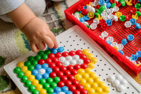 Toddler playing pegboard mosaic. Early child development. Fine motor skills. Learning and creativityの写真素材