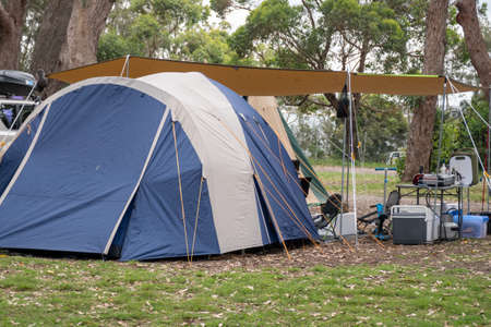 Family tent setup at the campsite surrounding by nature in caravan holiday park. Camping vacationの写真素材