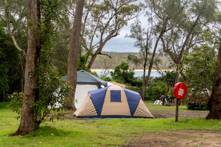 Family tent setup at the campsite surrounding by nature in caravan holiday park. Camping vacationの写真素材