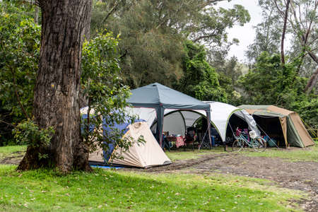Family tent setup at the campsite surrounding by nature in caravan holiday park. Camping vacationの写真素材