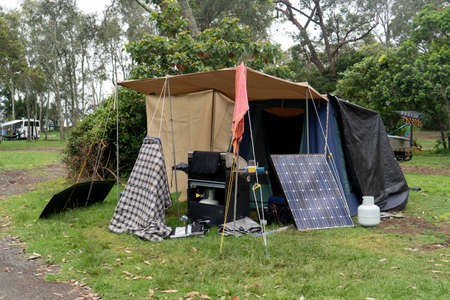 Portable foldable solar panels and Tent at the campsite surrounding by nature. Camping and recreation conceptの写真素材