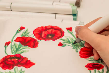 Hand drawing a red poppy wreath sketch in a sketchbook with alcohol based sketch drawing markers....